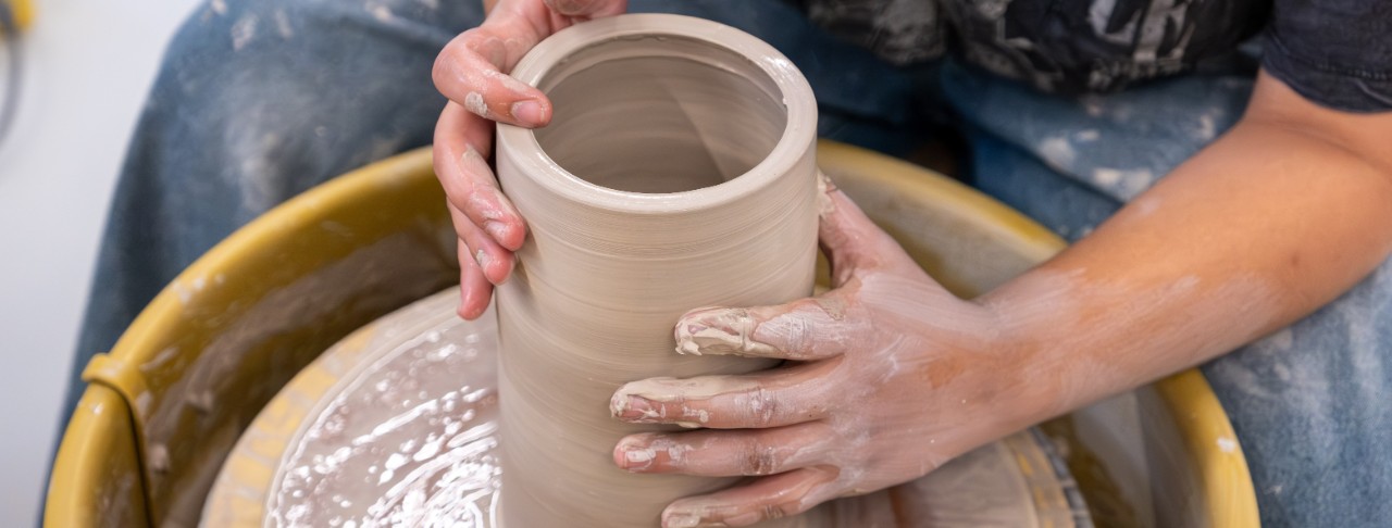 Student working with clay on the ceramics wheel.